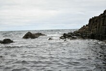 Beautiful Shot Of Ancient Basalt Stone Formations Along The Seaside With Barnacles, Moss And Water