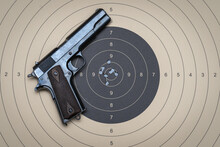 Firearms Shooting, Model 1911 Pistol And Target For Shooting With Bullet Holes In The Center.