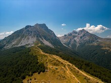 Aerial Shot Of Green-covered Mount Komovi Under The Blue Sky In  Montenegro