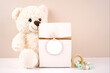 © millefloreimages - Gift with round thank you favor card tag product mockup. Baby shower 1st birthday christening gender neutral. Styled with white teddy bear against a beige and white background. Negative copy space.