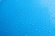 Water drops on light blue background, top view