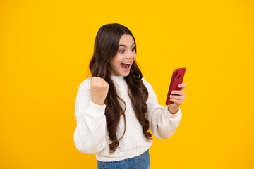 Canvas Print - Excited teenager girl child using mobile phone, chatting on web. Mobile app for smartphone. Children lifestyle concept.