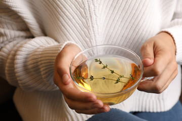 Woman drinking tasty herbal tea, closeup view