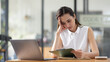 © David - Portrait of tired young business Asian woman work with documents tax laptop computer in office. Sad, unhappy, Worried, Depression, or employee life stress concept