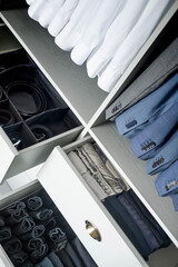 Wall Mural - Man cupboard clothes storage organization neatly folded belt underwear shirt and socks