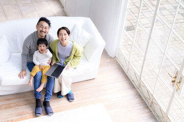 Wall Mural - Image of an Asian couple with a cute child in the living room　bird's eye view　