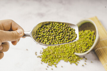 fresh mung beans in ceramic dishes against a white stone background, coppy space.