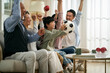 © imtmphoto - three generation asian family watching soccer game telecast on tv together at home