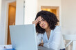 © Graphicroyalty - Exhausted businesswoman having a headache in home office. African American creative woman working at office desk feeling tired. Stressed business woman feeling eye pain while overworking