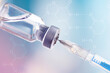 Glass vial and syringe with injection over blue background. Vaccination or beauty therapy concept.