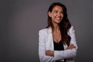 Wall Mural - Studio portrait of attractive brunette haired woman posing at dark background