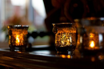 Wall Mural - Closeup view of candles with glass pots for home decor on a wooden surface