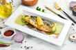 Fried mackerel fillet with lemon vegetables on a white plate. Top view. Rustic style.
