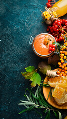 Jam. Viburnum berries and sea buckthorn with honey. Foods with a high content of vitamin C. On a dark background. top view