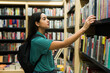 © AntonioDiaz - Female university student buying an academic book at the bookstore