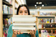 Happy reader woman buying a lot of books at the store