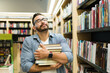 © AntonioDiaz - Cheerful reader feeling happy buying a lot of books
