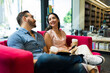 © AntonioDiaz - Cheerful woman at the book shop laughing with her boyfriend while reading