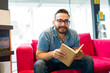© AntonioDiaz - Handsome man enjoying a book while book shopping