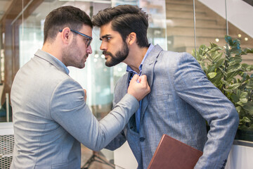 business conflict between two business men in formal-wear in office. boss and employee with aggressi