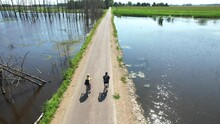 Summer Time In Eastern Europe. Two Happy, Positive Boys On Bikes, Driving Through Sunny Forest And Lake