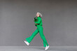 © VISTA by Westend61 - Woman with plastic bottles jumping in front of wall