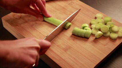 Canvas Print - woman hands cutting leek on wooden board close up