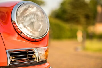 Sticker - Closeup of the headlight of an old red classic car