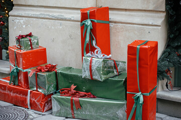 Wall Mural - Stylish red and green wrapped christmas gifts and presents at  building exterior. Modern christmas decor in city street. Winter holidays in Europe. Festive decorations