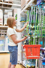 Poster - Woman buying a mop for cleaning in store