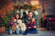 © Olena - Happy young family playing with cute pets Samoyed puppies near fireplace. Christmas holiday concept, spend time together. Mother, father, daughter, baby, white dogs celebrating New Year at cozy home.