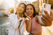 © Drobot Dean - Two young beautiful smiling happy asian girls taking selfie