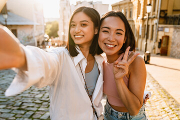 Selfie of two young beautiful happy smiling asian girls