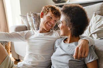 Wall Mural - Young beautiful happy smiling interracial couple looking at each other