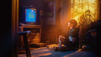 Handsome Child Playing Eight Bit Arcade Video Game on a Console at Home in His Stylish Room with Eighties Interior. Young Boy Reaches End of Level and Wins. Nostalgic Retro Childhood Concept.