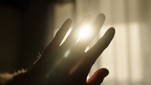 Male Hand Playing With Sunlight Glare Coming Through Window