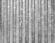 Corrugated vertical sheet aluminum facade. Grunge grainy metal texture. Silver color industrial pattern. Garage construction gray striped wall.