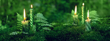 Burning Candles On Moss, Dark Green Blurred Natural Background. Magic Candles For Witch Ritual In Forest, Mysterious Fairy Scene. Banner