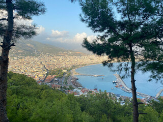 A beautiful tourist city with modern buildings on a mountain with trees, a view from the top to the roofs and the sea on vacation in a warm tropical eastern paradise country southern resort