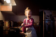 © Cavan Images - Happy girl looking away while preparing food in kitchen at home