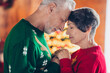 Side profile photo of two peaceful pensioners sweethearts closed eyes hands touch hold together wear christmas warm sweaters idyllic love indoors