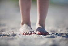 A View Of A Young Child's Sandy Feet At The Beach.