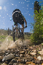 A Mountain Biker Splashing Though A Stream On Donner Summit In California. (blurred Motion)