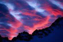 Alpenglow On Lenticular Clouds Above A High Sierra Ridge.