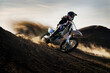 © Cavan Images - Dust and dirt fly as a young man banks his dirt bike into a hard turn while motocross riding on the surreal dunes near Cameron, AZ.