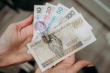 Żarówka na tle banknotów polskich