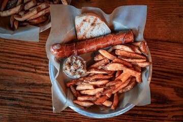 Sticker - Top view of the plate with delicious fried sausage, french fries and a slice of bread