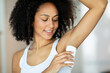African american woman in bathroom applying deodorant 