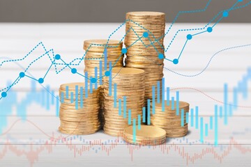 Wall Mural - Stack of  coins with graph or chart on the desk