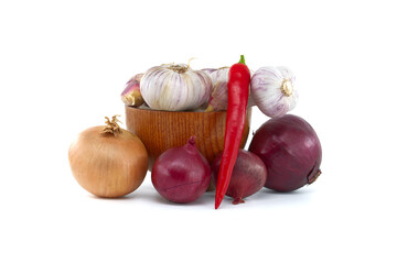 Garlic in bowl near to chili pepper and onions